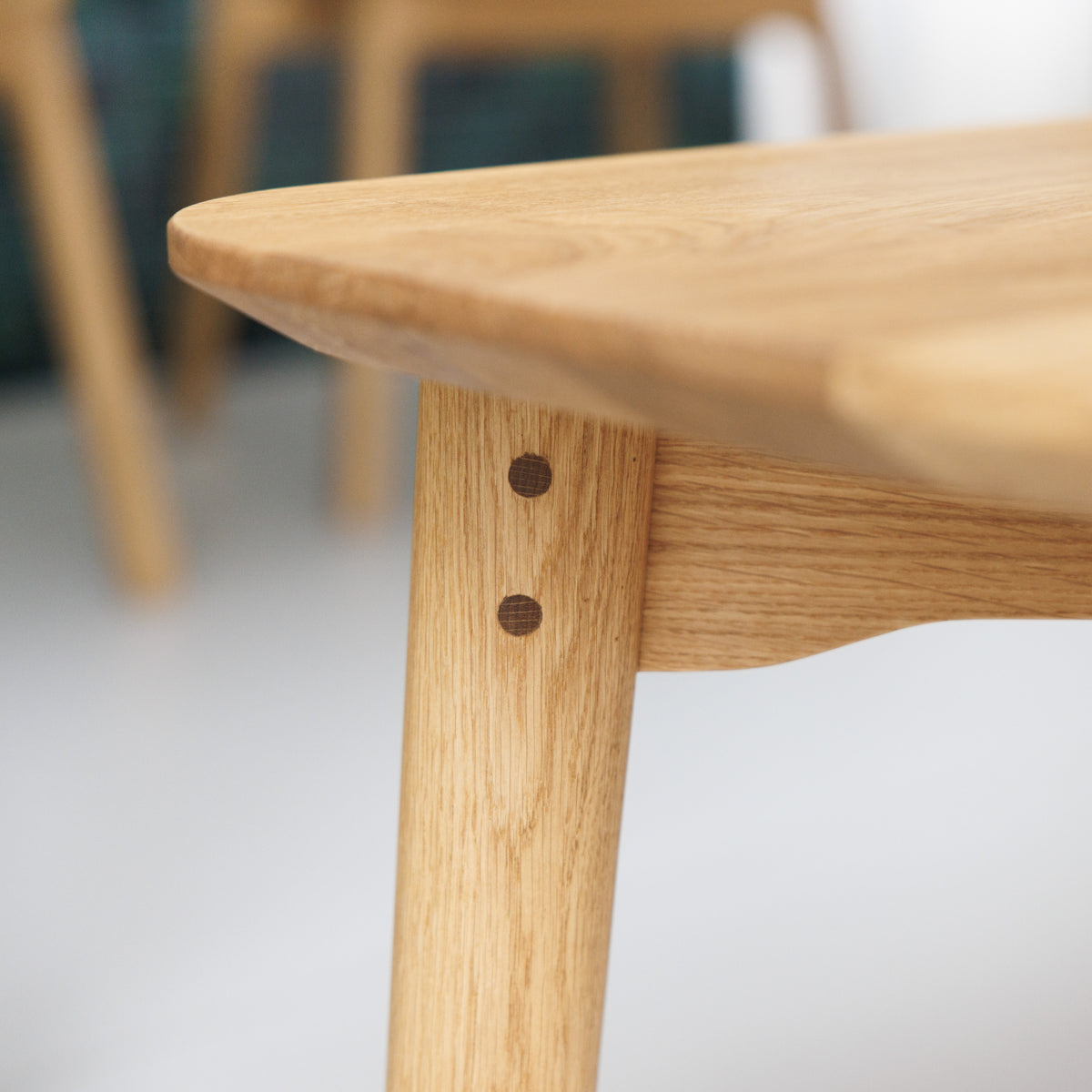 Sitzbank mit eleganten Beinen und sichtbaren Holzdübeln